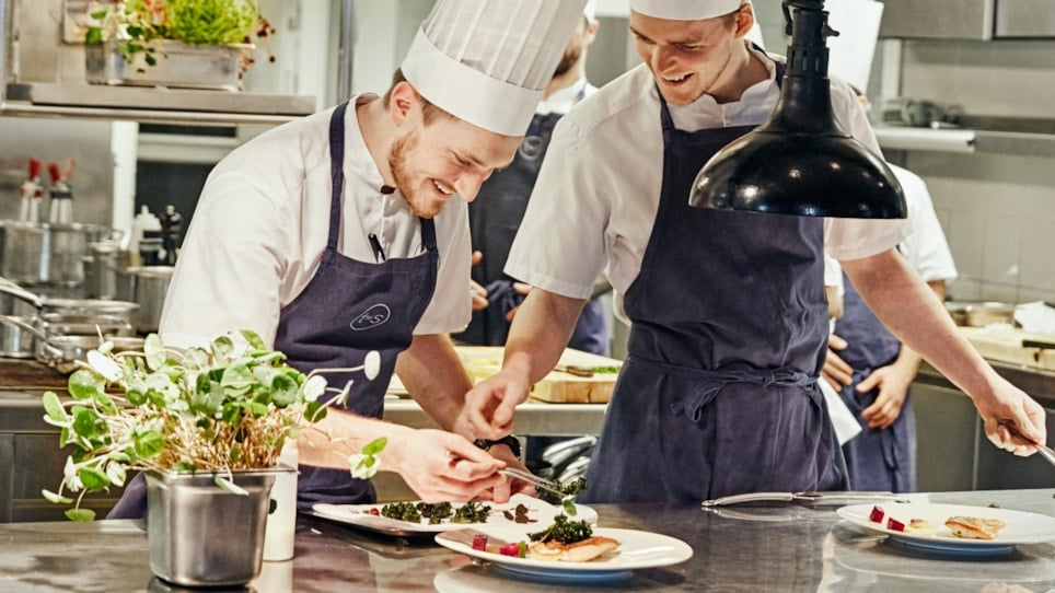 Kokker som lager mat på et restaurantkjøkken