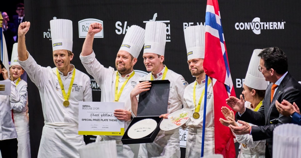 et bilde av fire menn i kokkejakker som holder diplomer og premier som bevis på prisen for beste fiskerett i Bocuse d'Or 