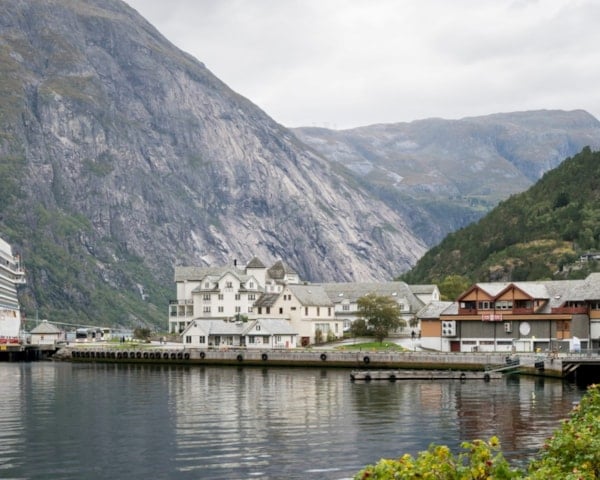 Et cruiseskip som ligger til havn i en fjord.